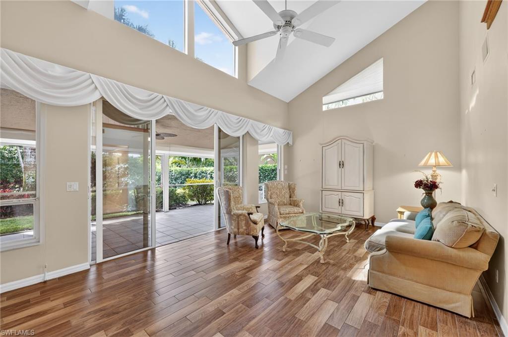 8534 Chase Preserve Drive Naples, FL 34113 - Photo 19 of 44 Living area with a ceiling fan, wood-look tile finished floors, and a high ceiling