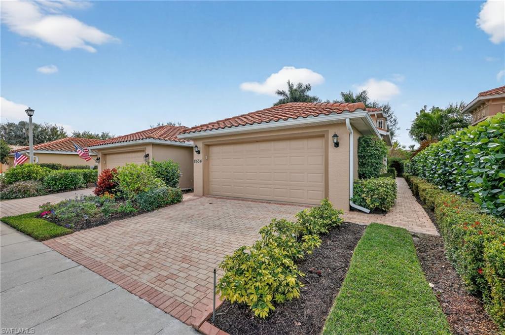 8534 Chase Preserve Drive Naples, FL 34113 - Photo 2 of 44 Mediterranean / spanish-style house featuring stucco siding, decorative driveway, a tile roof, and an attached garage