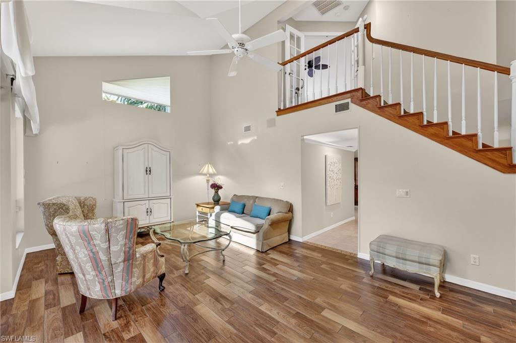 8534 Chase Preserve Drive Naples, FL 34113 - Photo 22 of 44 Living room featuring wood-look tile finished floors, vaulted ceiling, and ceiling fan