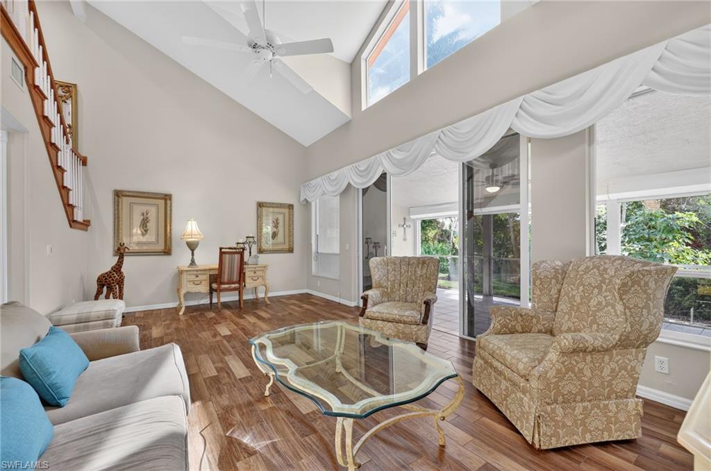 8534 Chase Preserve Drive Naples, FL 34113 - Photo 23 of 44 Living room featuring a ceiling fan, wood-look tile finished floors, and vaulted ceiling