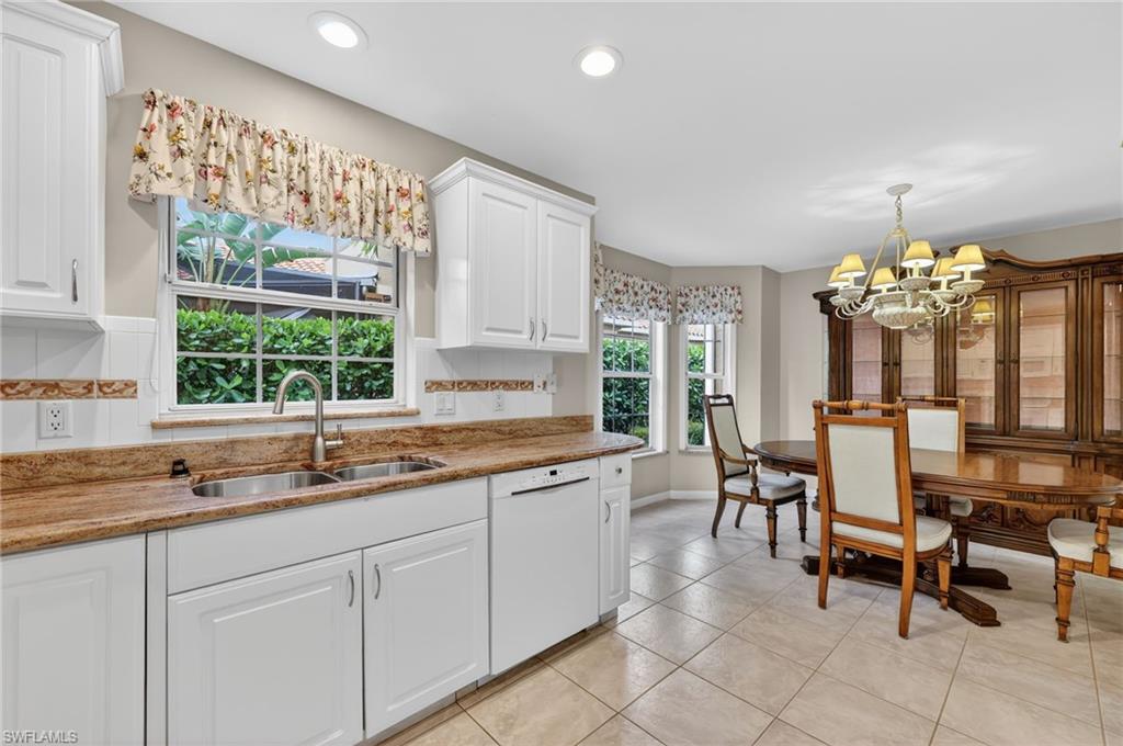 8534 Chase Preserve Drive Naples, FL 34113 - Photo 10 of 44 Kitchen with light stone countertops, white cabinets, dishwasher, suspended lighting, and light tile floors