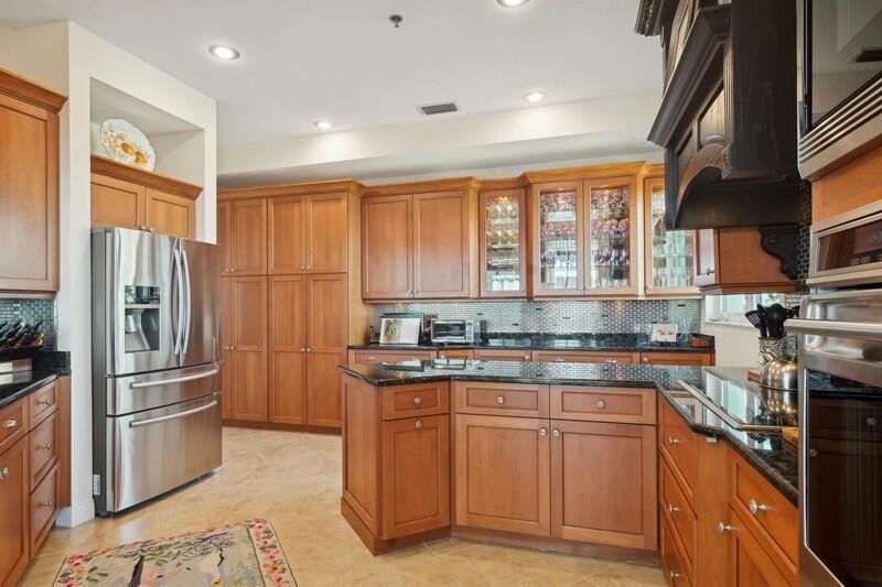 1130 Southwest Chapman Way, Unit 509 Palm City, FL 34990 - Photo 11 of 29 a kitchen with stainless steel appliances granite countertop a refrigerator a sink a stove and white cabinets