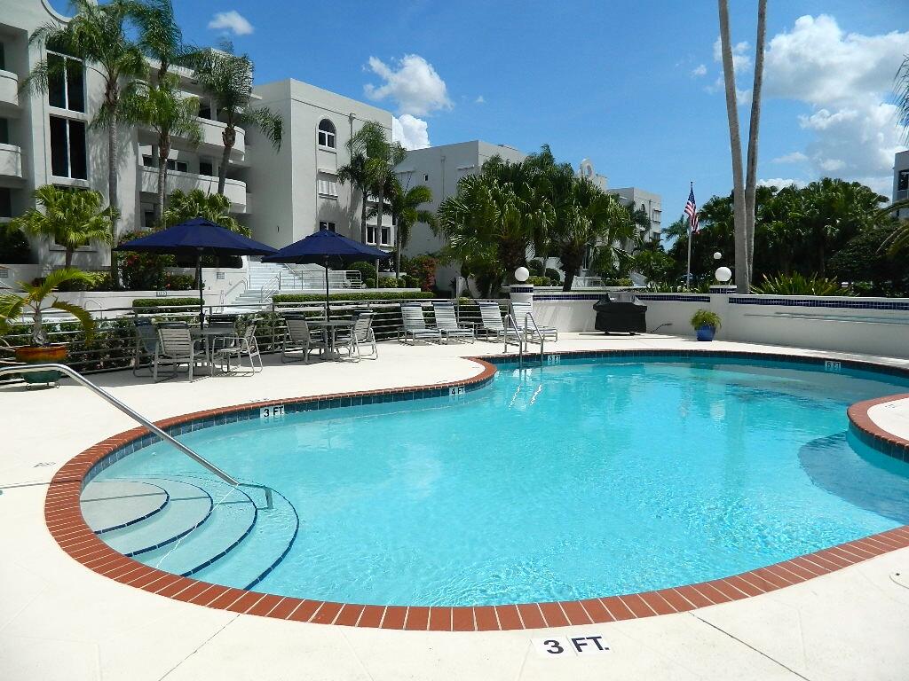 1130 Southwest Chapman Way, Unit 509 Palm City, FL 34990 - Photo 26 of 29 a view of a swimming pool with outdoor seating