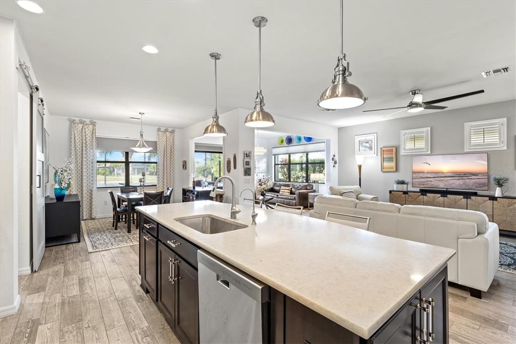 13856 RINUCCIO Street Venice, FL 34293 - Photo 12 of 63 a kitchen with stainless steel appliances granite countertop a sink a stove and chairs