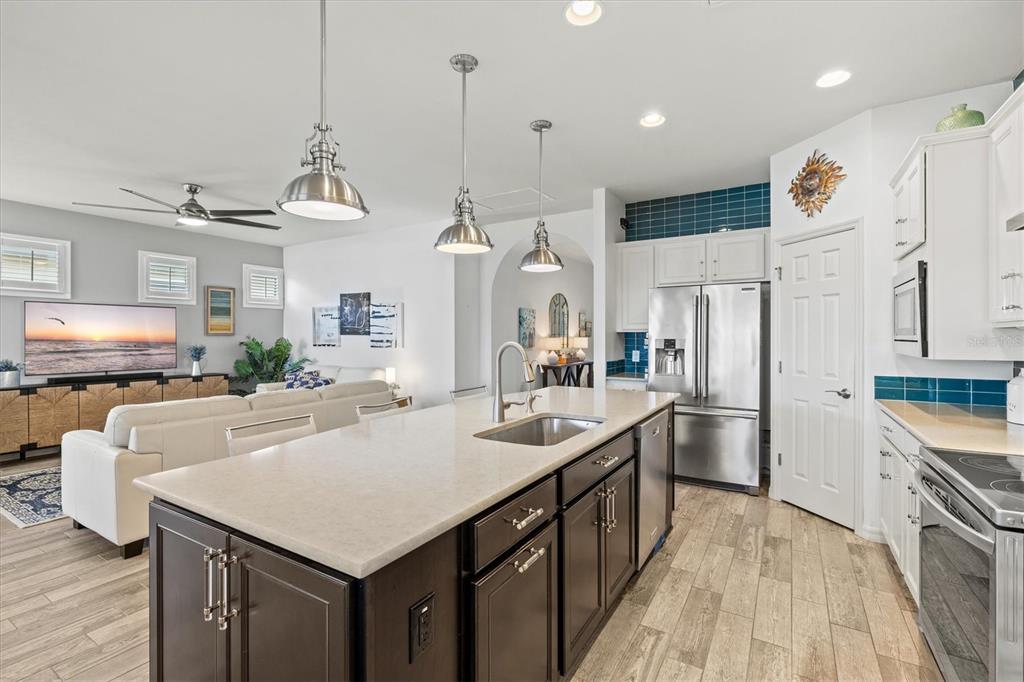 13856 RINUCCIO Street Venice, FL 34293 - Photo 13 of 63 a kitchen with stainless steel appliances granite countertop a sink a stove and a refrigerator