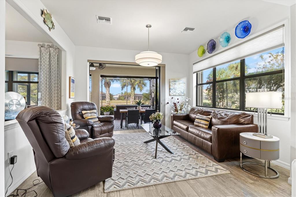 13856 RINUCCIO Street Venice, FL 34293 - Photo 17 of 63 a living room with furniture a flat screen tv and a large window