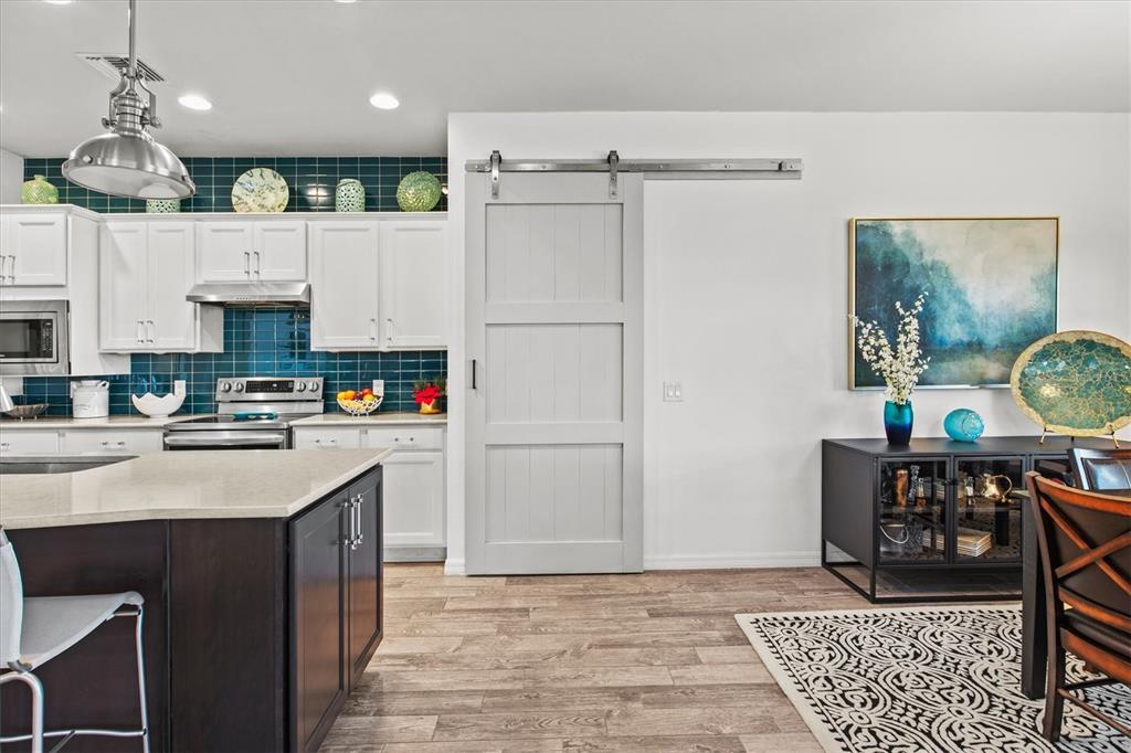 13856 RINUCCIO Street Venice, FL 34293 - Photo 20 of 63 a kitchen with kitchen island stainless steel appliances a table and chairs