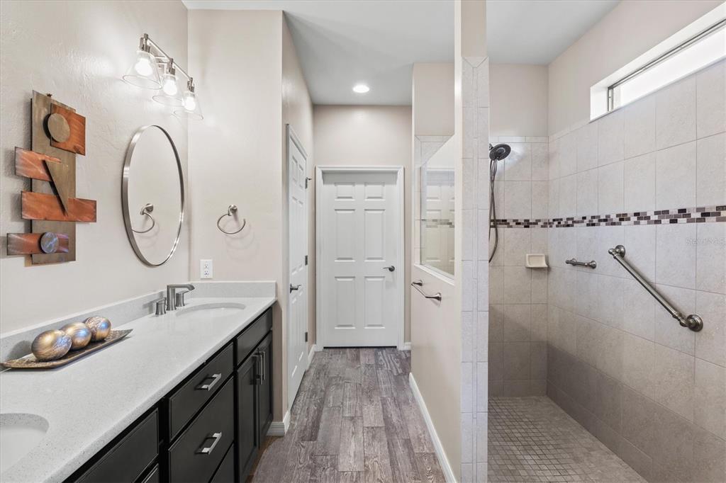 13856 RINUCCIO Street Venice, FL 34293 - Photo 25 of 63 a spacious bathroom with a double vanity sink a mirror and shower