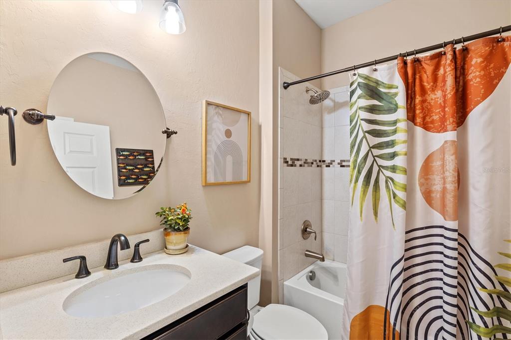 13856 RINUCCIO Street Venice, FL 34293 - Photo 28 of 63 a bathroom with a sink a mirror a bathtub and a shower