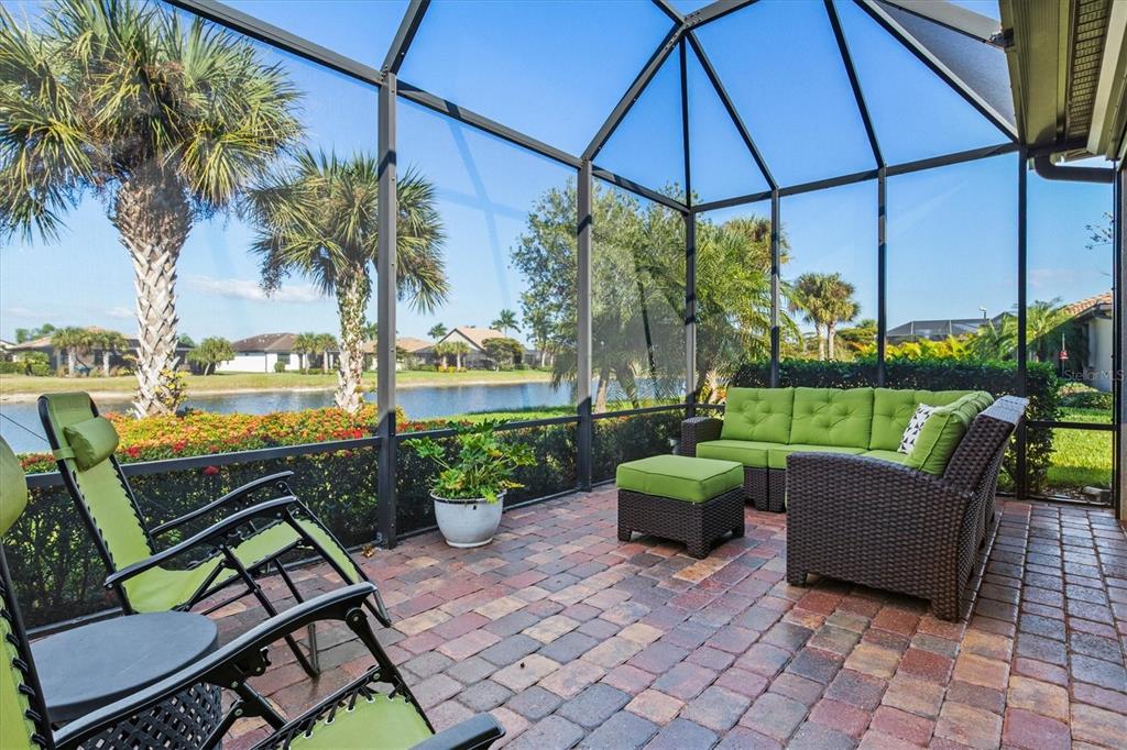 13856 RINUCCIO Street Venice, FL 34293 - Photo 37 of 63 a view of a patio with couches under an umbrella