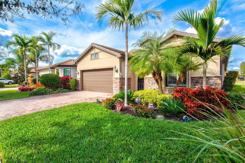 13856 RINUCCIO Street Venice, FL 34293 - Photo 4 of 63 a front view of a house with a yard and potted plants