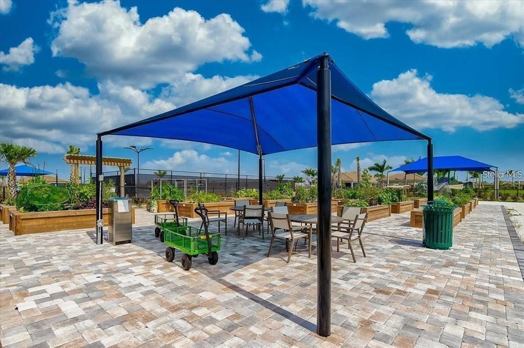 13856 RINUCCIO Street Venice, FL 34293 - Photo 58 of 63 a view of a patio with a table and chairs under an umbrella