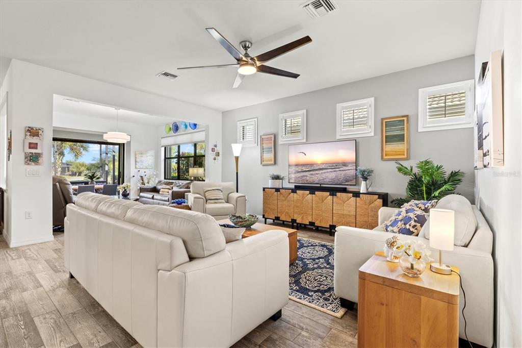 13856 RINUCCIO Street Venice, FL 34293 - Photo 7 of 63 a living room with furniture and a wooden floor