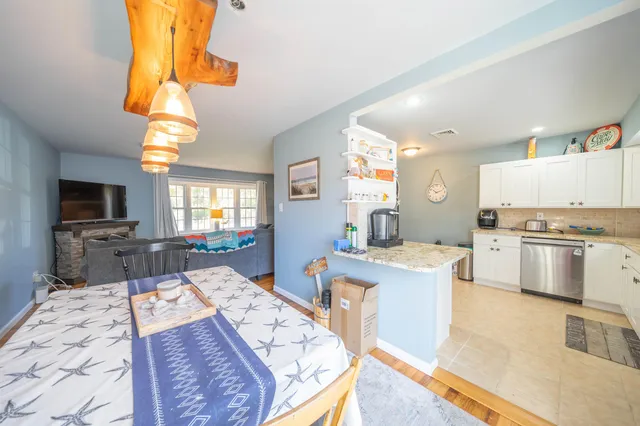 a living room with stainless steel appliances furniture fireplace and a flat screen tv