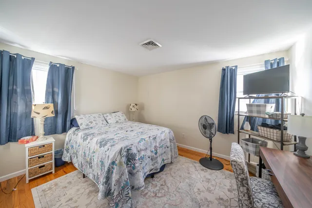 a bedroom with a bed and wooden floor