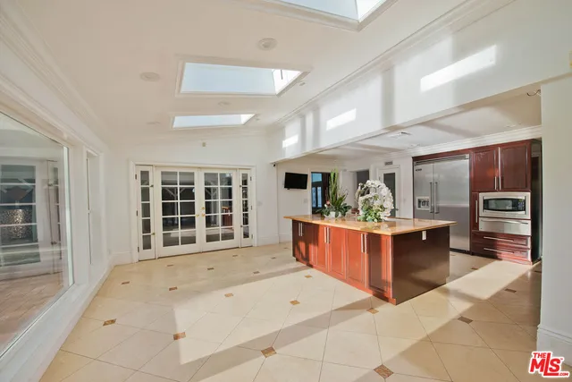 a dining hall with stainless steel appliances granite countertop a stove and more cabinets