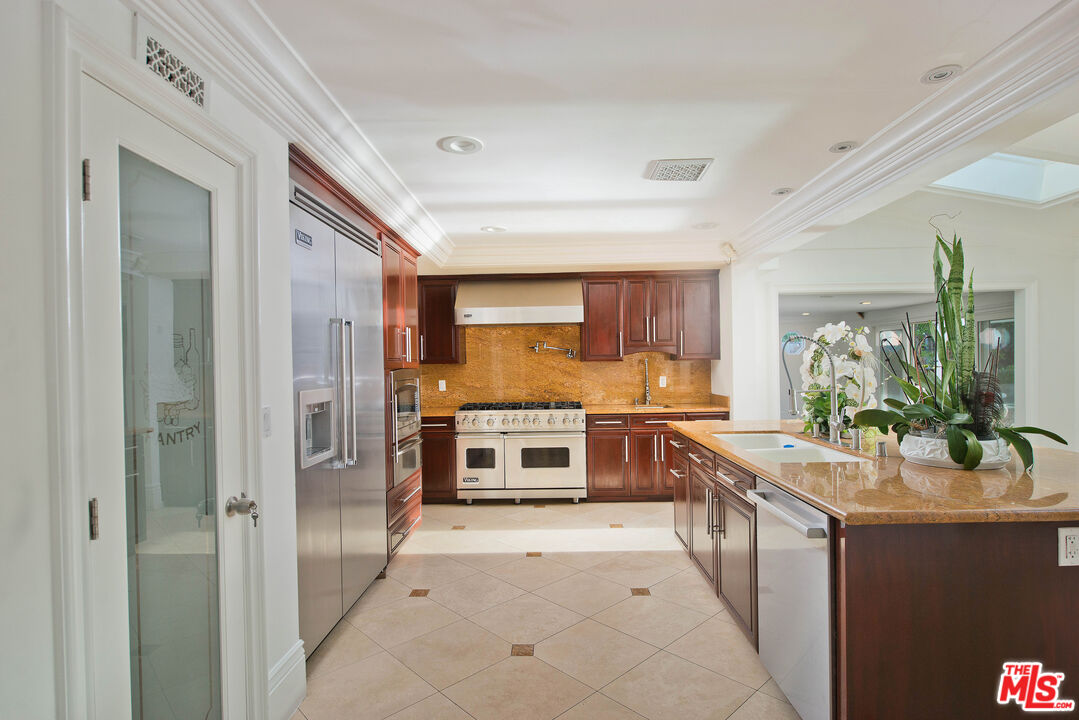 11753 Castillo Lane Porter Ranch, CA 91326 - Photo 12 of 44 a kitchen with stainless steel appliances a stove and more cabinets
