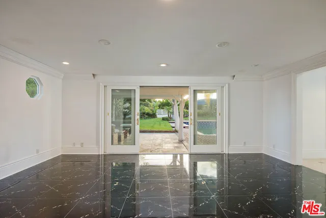 a view of empty room with floor to ceiling window and wooden floor