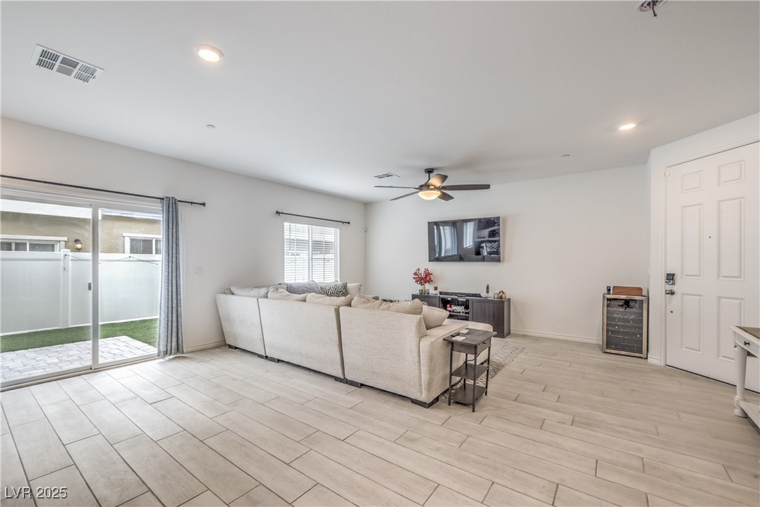 7232 North Decatur Boulevard, Unit 4 North Las Vegas, NV 89084 - Photo 8 of 36 Living room featuring beverage cooler, visible vents, baseboards, ceiling fan, and light wood-style flooring