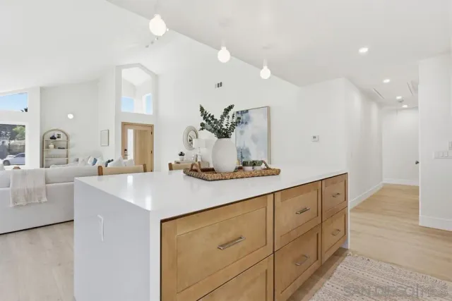 a view of kitchen island a sink wooden floor and living room view