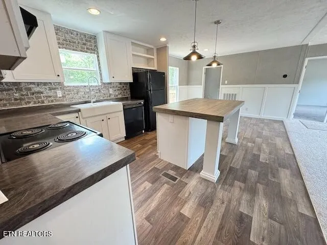 a kitchen with a sink a stove a refrigerator and a window