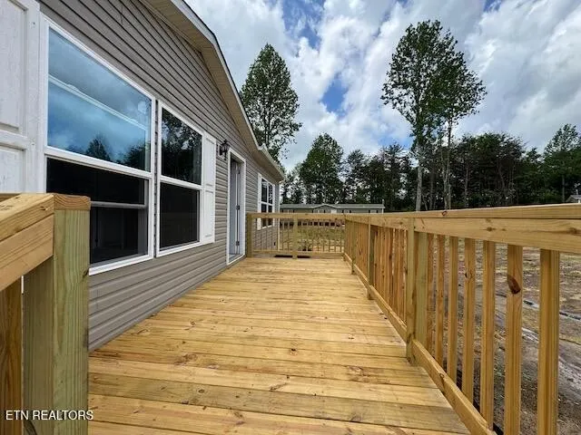 a view of balcony with wooden floor and fence