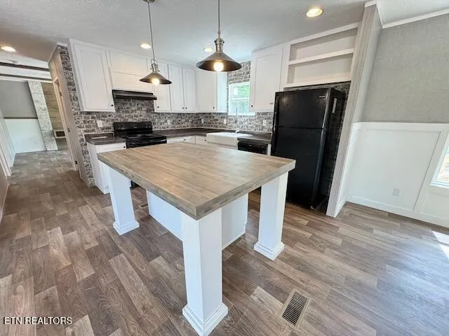 a kitchen with a refrigerator a sink dishwasher and a stove with wooden floor