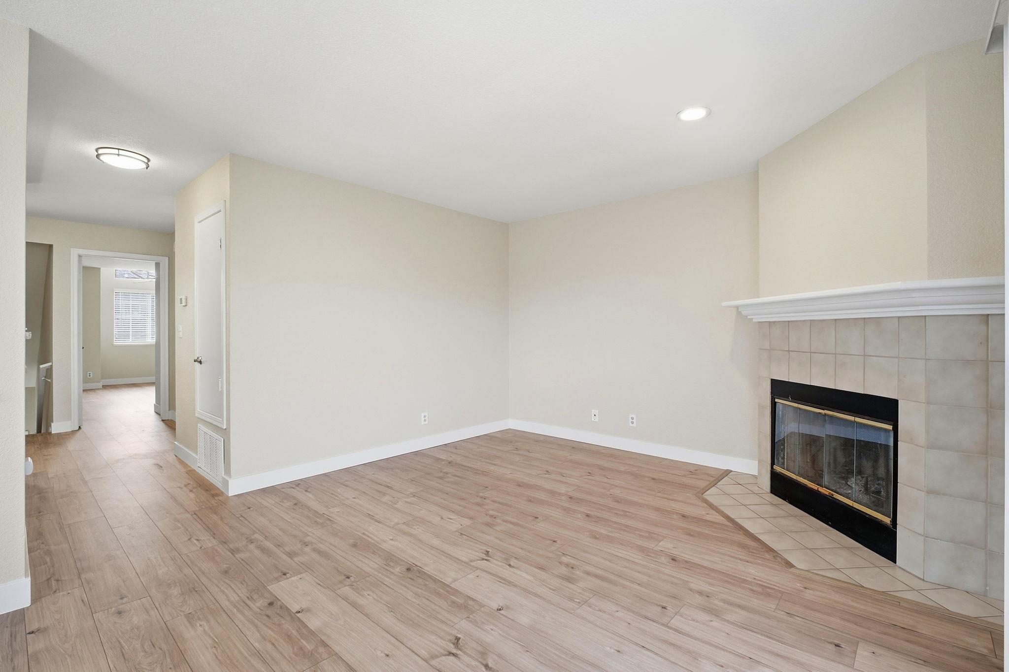 58 Trestle Drive Hayward, CA 94544 - Photo 9 of 36 a view of an empty room with wooden floor fireplace and a window