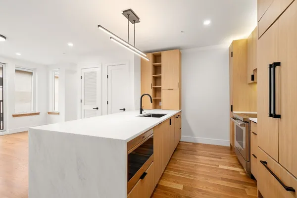 a large kitchen with a sink and refrigerator