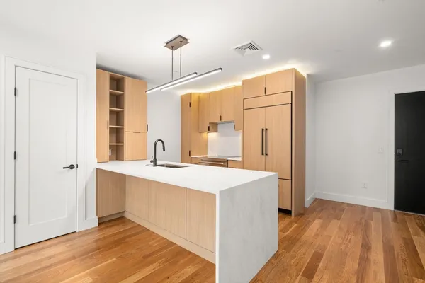 a kitchen with kitchen island a sink appliances and cabinets