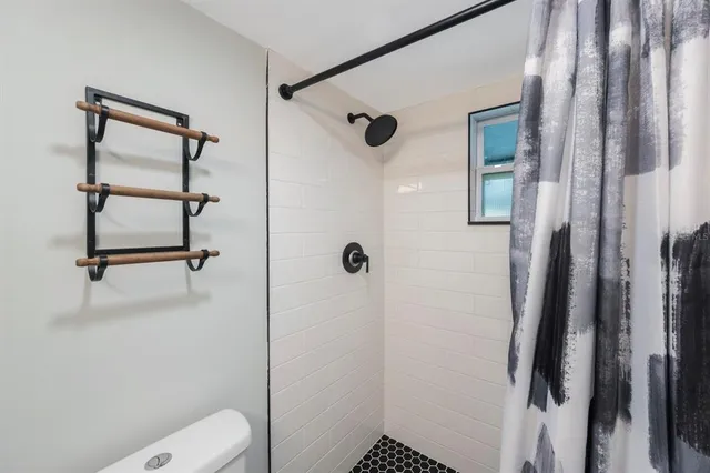 a bedroom with a bed and a dresser next to a window