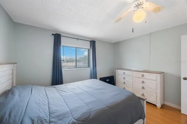 a bedroom with a bed and a ceiling fan