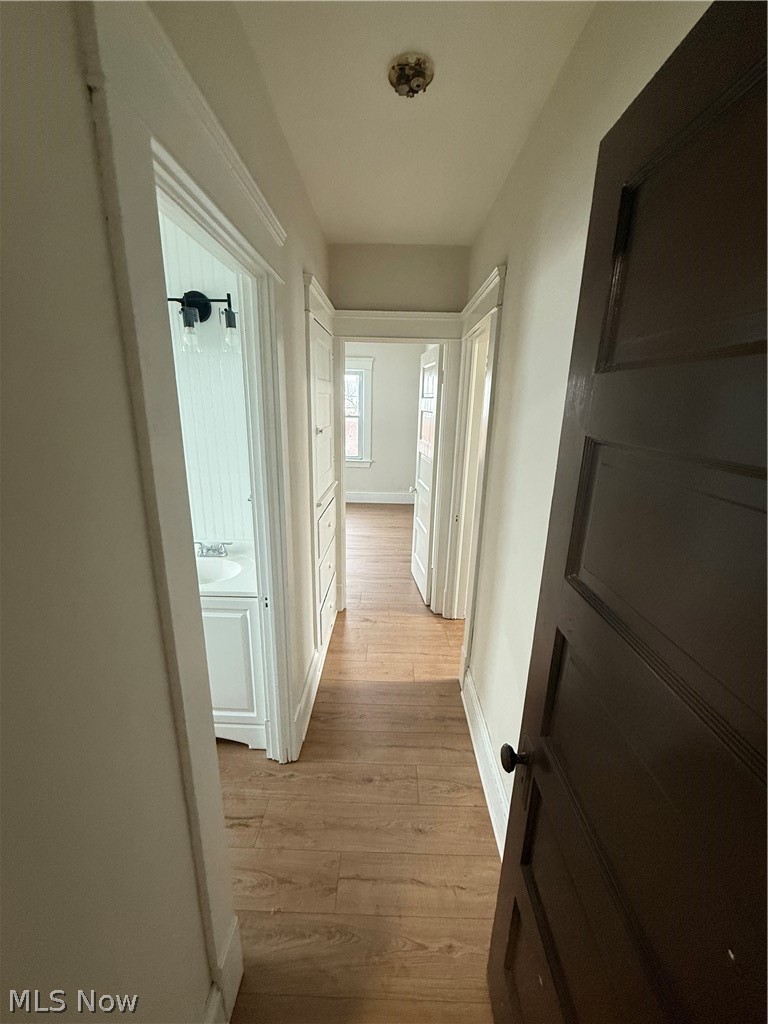 3612 Riverside Avenue Cleveland, OH 44109 - Photo 19 of 22 Hallway featuring wood-finish flooring, white painted walls, and white trim