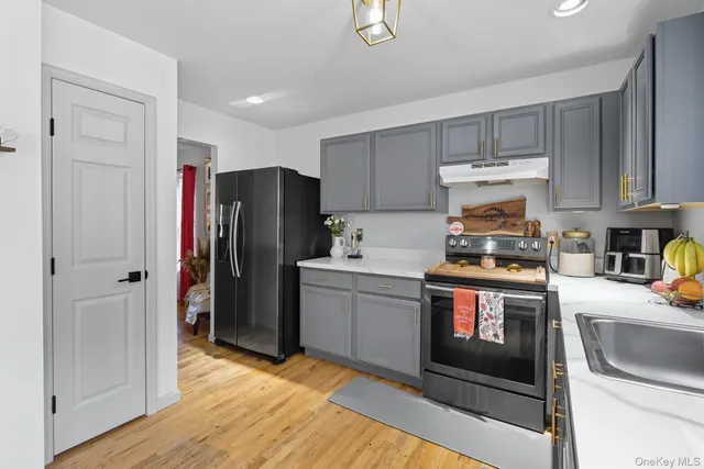 a kitchen with a refrigerator sink and cabinets