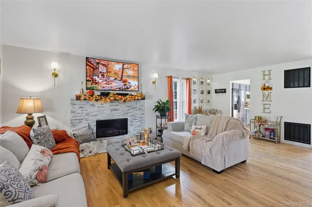 a living room with furniture a flat screen tv and a fireplace