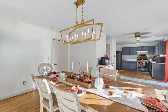 a view of a dining room with furniture a chandelier and wooden floor