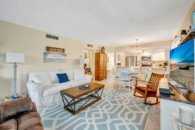 a living room with furniture a rug and a view of kitchen