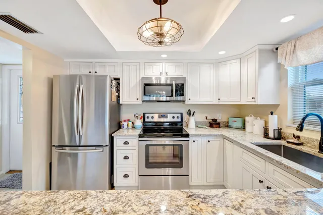 a kitchen with granite countertop a refrigerator stove and microwave