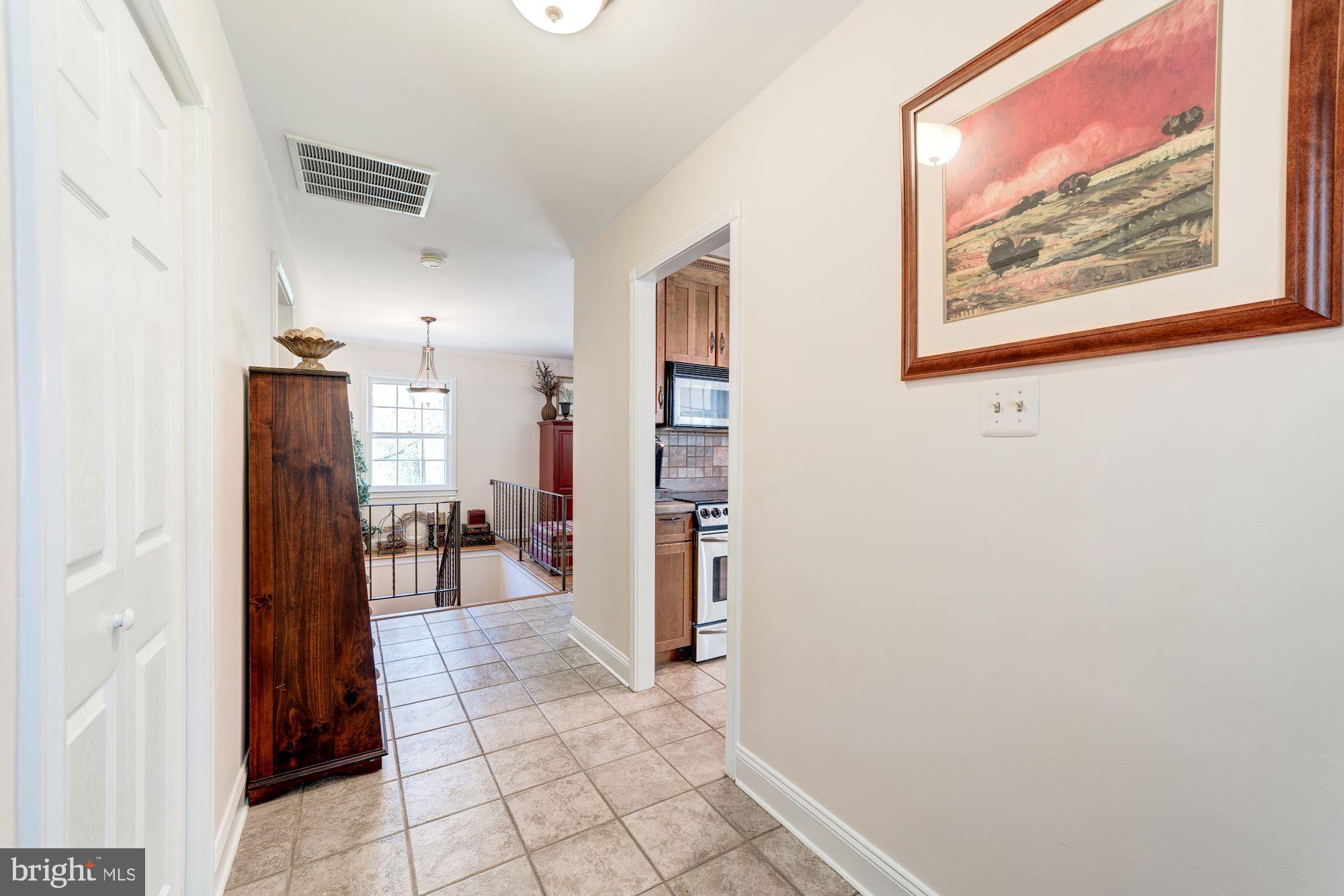 11310 Myrtle Lane Reston, VA 20191 - Photo 11 of 42 a view of a hallway with wooden floor and dining room