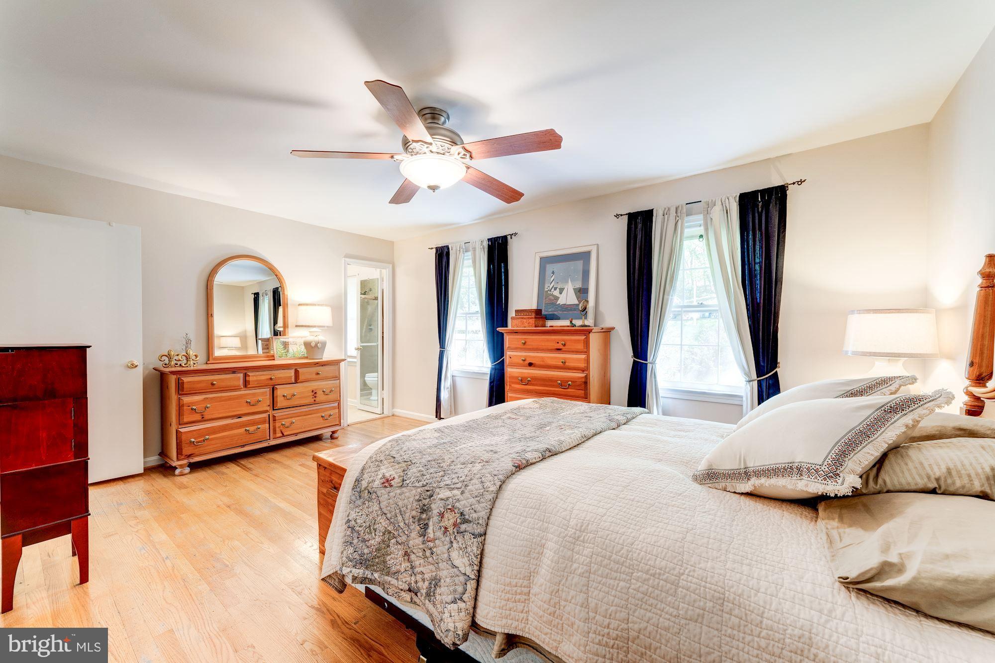 11310 Myrtle Lane Reston, VA 20191 - Photo 20 of 42 a bedroom with a bed and dresser with mirror