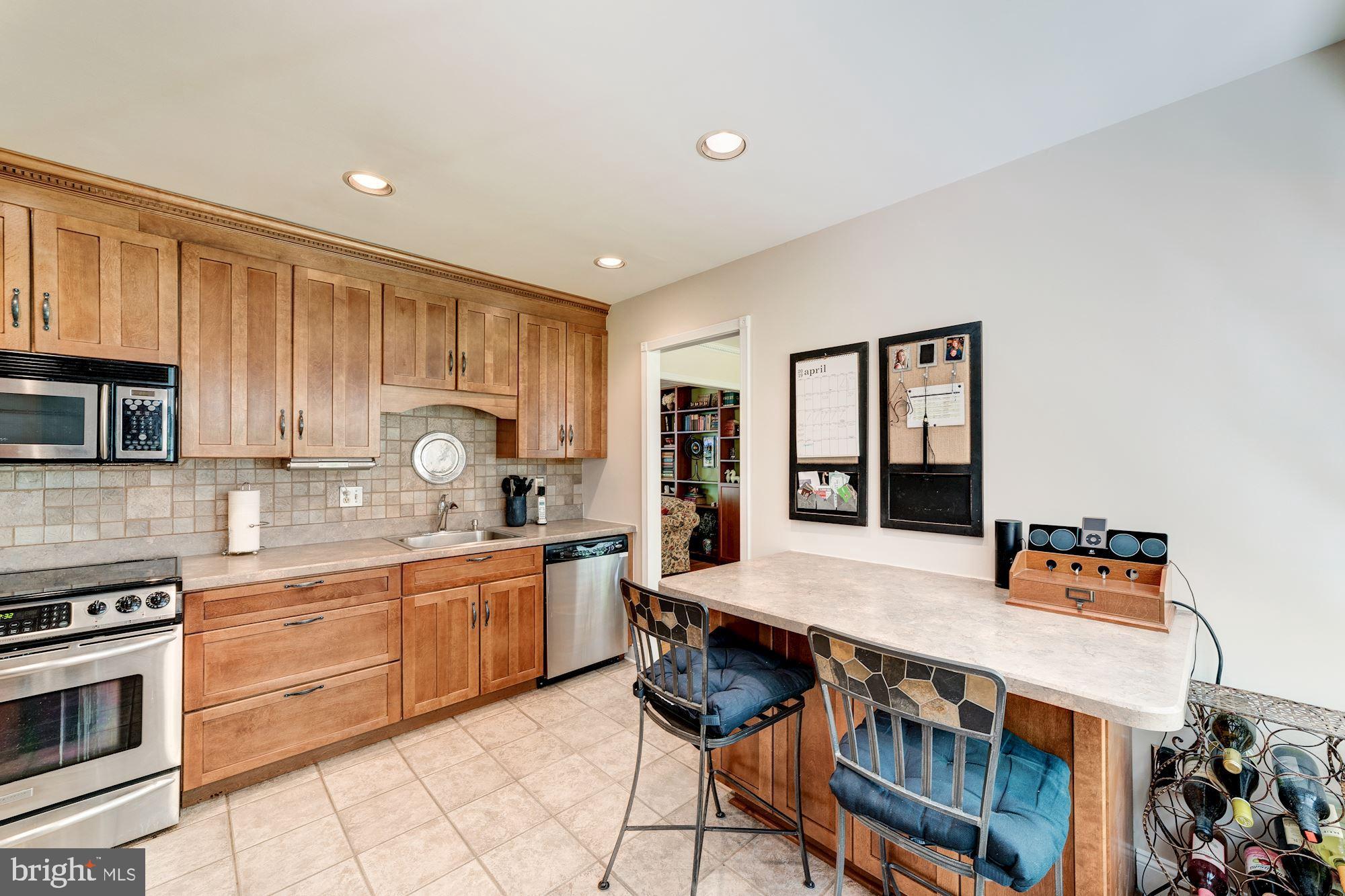 11310 Myrtle Lane Reston, VA 20191 - Photo 5 of 42 a kitchen with granite countertop a stove top oven sink and cabinets