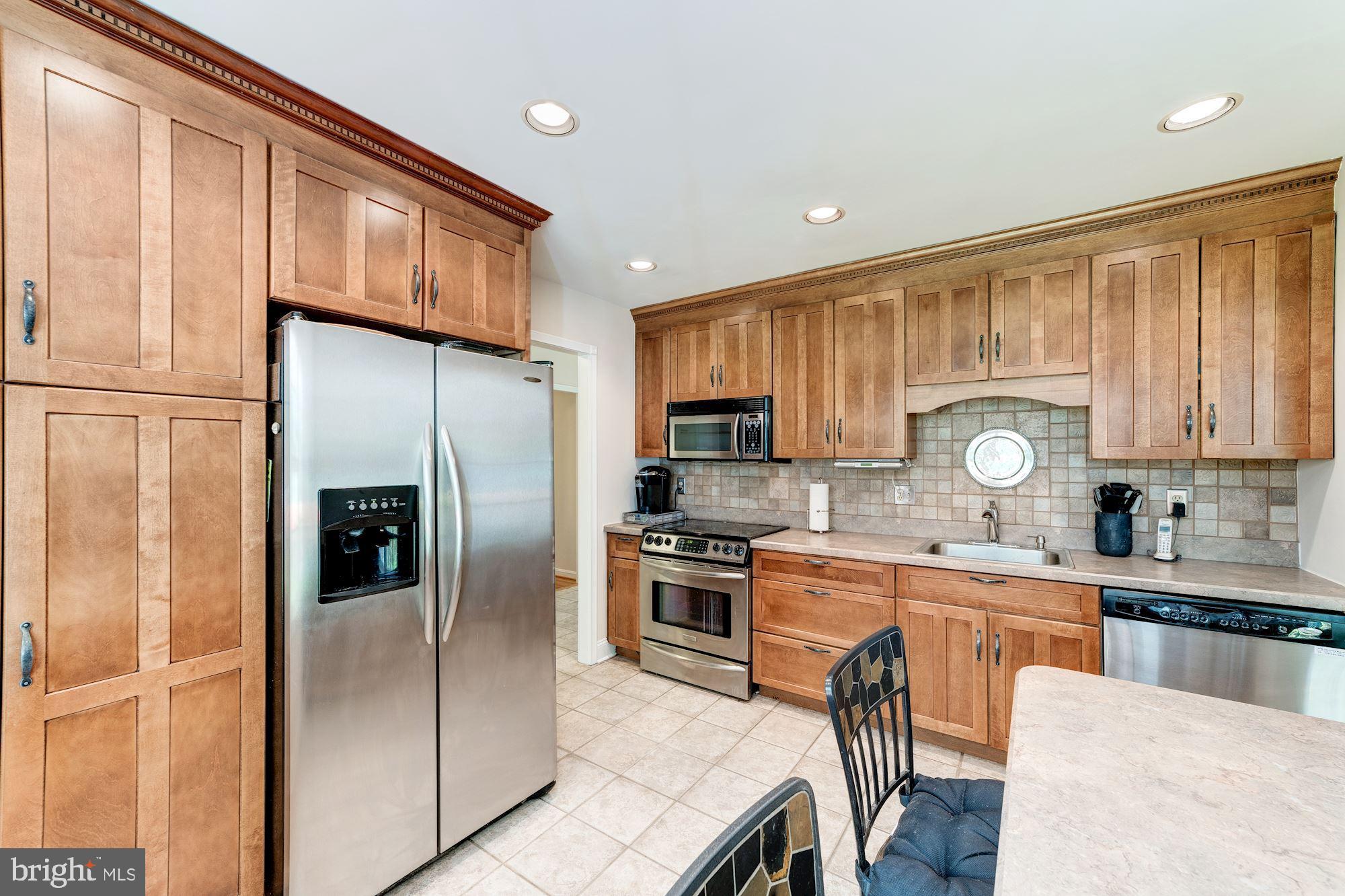 11310 Myrtle Lane Reston, VA 20191 - Photo 6 of 42 a kitchen with a refrigerator a sink and cabinets