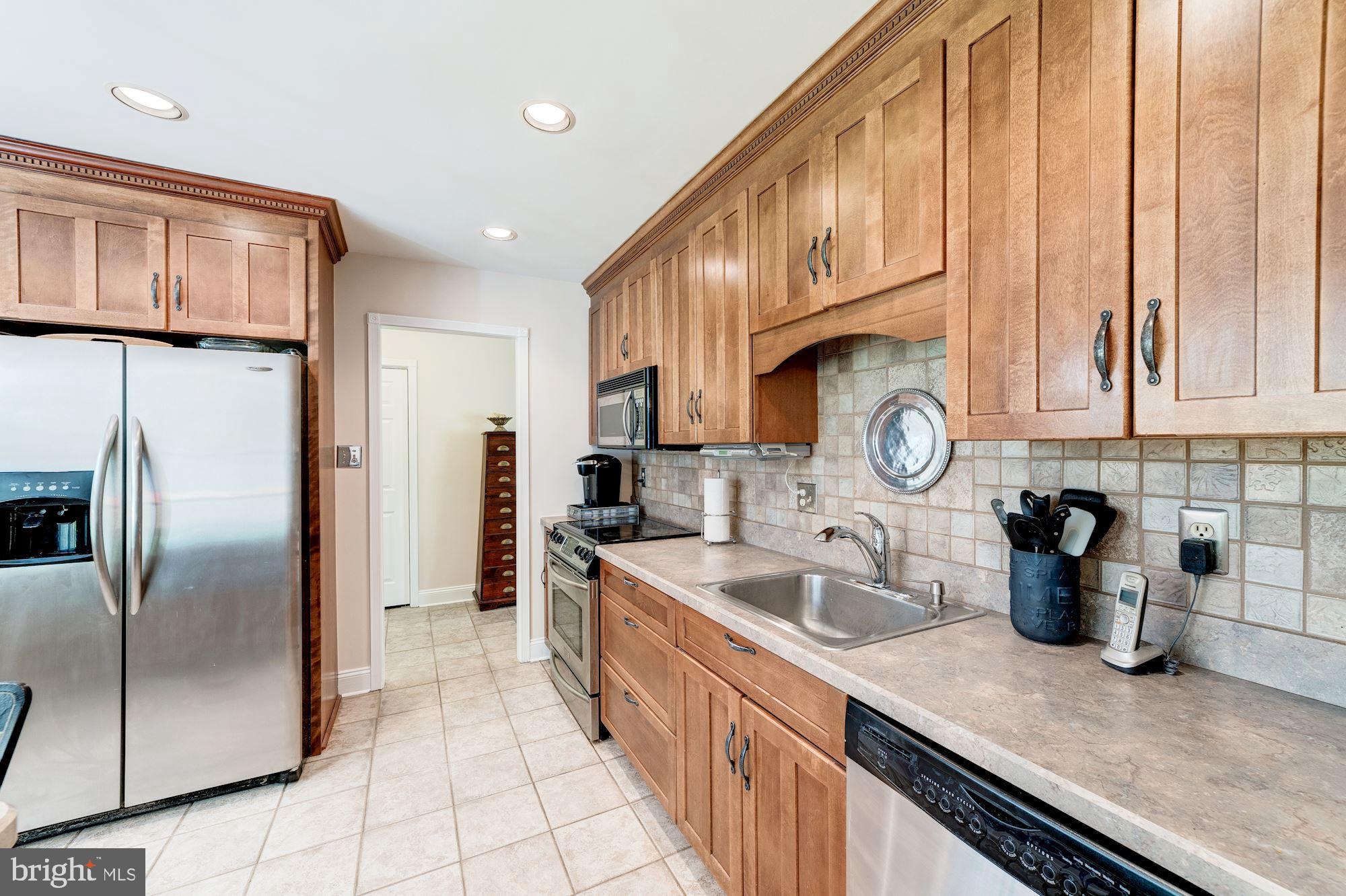 11310 Myrtle Lane Reston, VA 20191 - Photo 8 of 42 a kitchen with stainless steel appliances granite countertop a sink a stove and a refrigerator