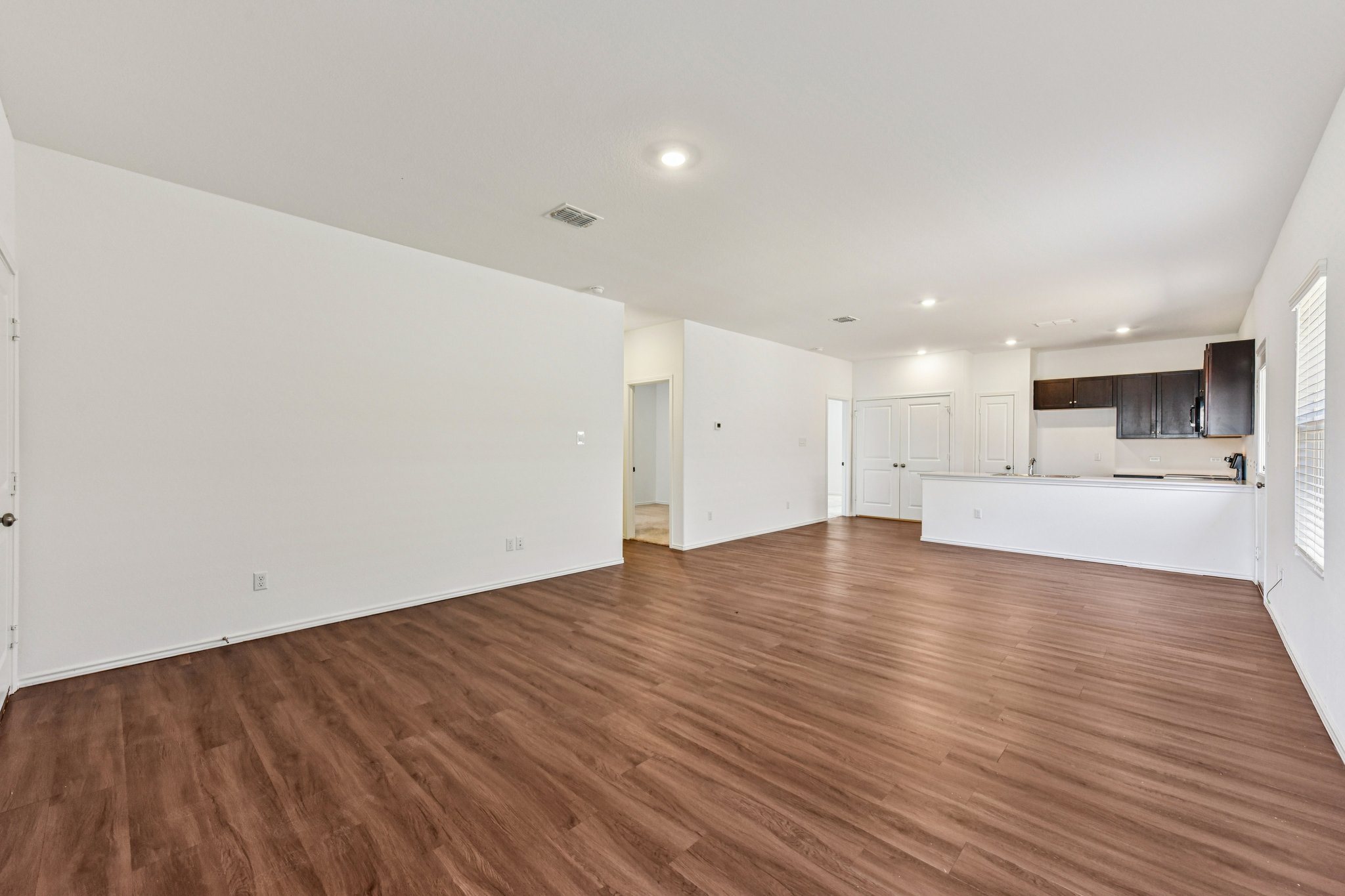 312 The Bad Way Jarrell, TX 76537 - Photo 5 of 38 a view of empty room with wooden floor and kitchen
