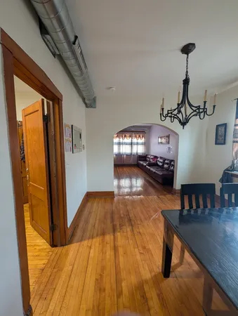 a living room with furniture floor to ceiling window and wooden floor