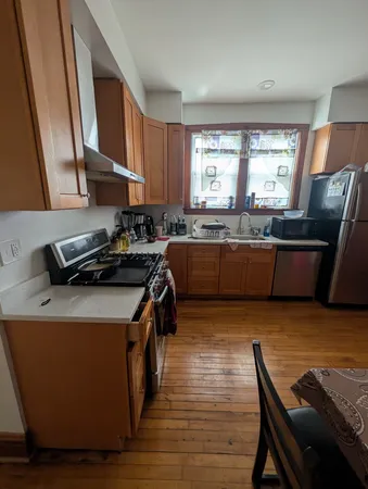 a kitchen with stainless steel appliances granite countertop a sink wooden cabinets and a refrigerator
