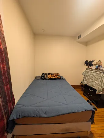 a bedroom with a bed and a small window