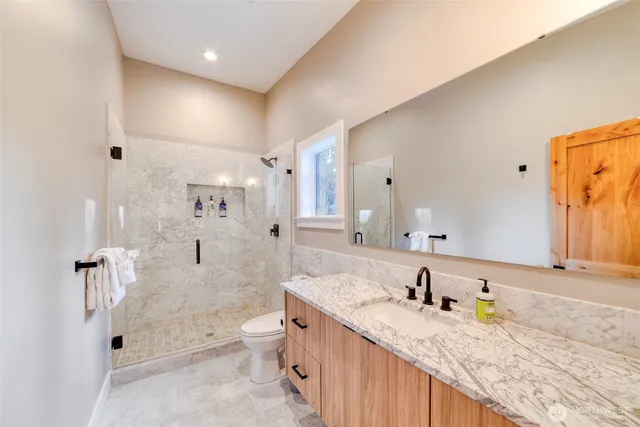 a spacious bathroom with a granite countertop sink mirror and shower