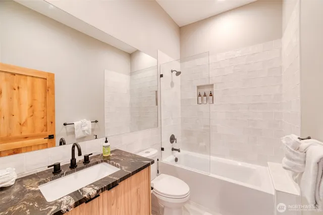 a bathroom with a granite countertop sink toilet tub and shower