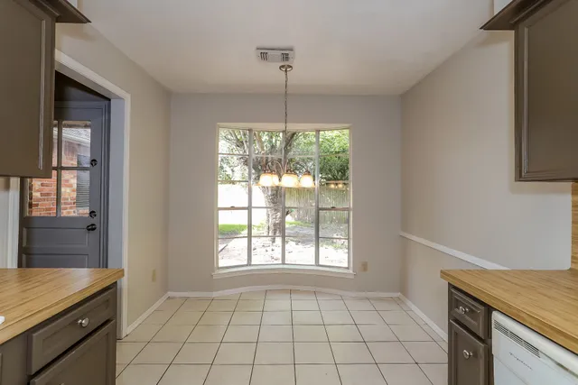 a view of an empty room with window and cabinet